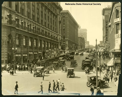 Black-and-white street scene in downtown Omaha in the 1920s, with streetcars and early automobiles
