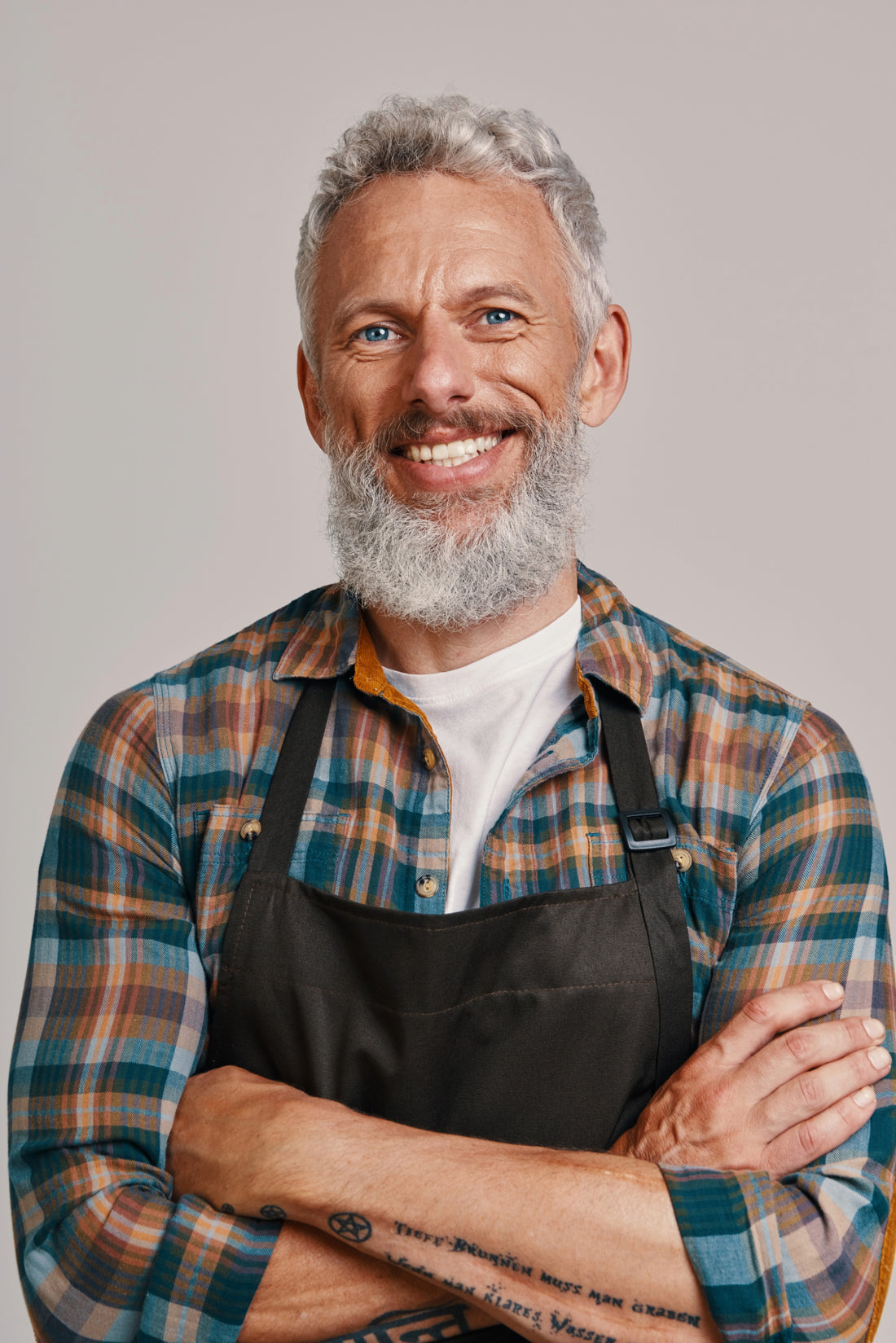 Smiling cook in a plaid shirt and apron