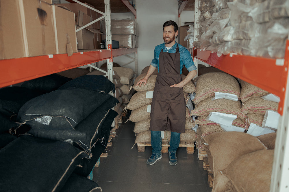 Worker checking stacked bulk bags in a warehouse