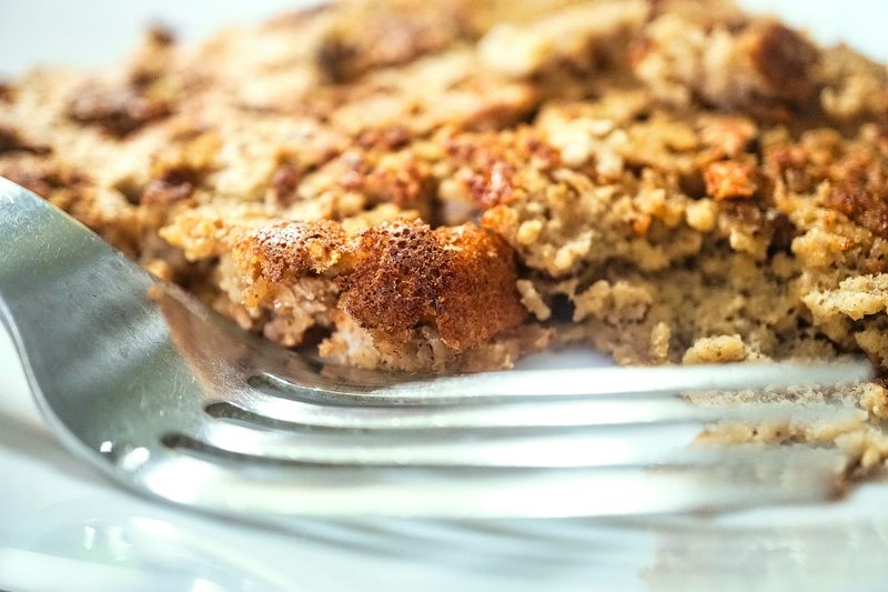 Close-up of golden baked cornbread dressing with a fork